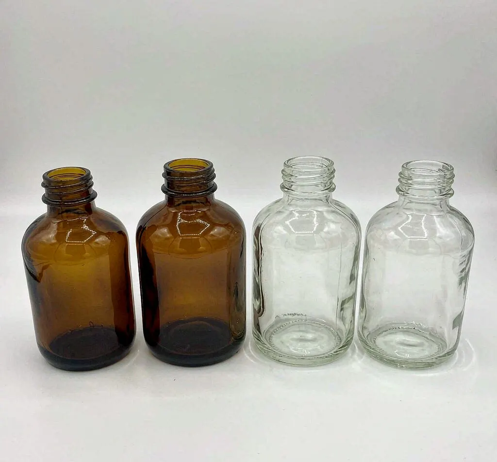 Short squat amber and clear stout glass bottles with continuous thread finish