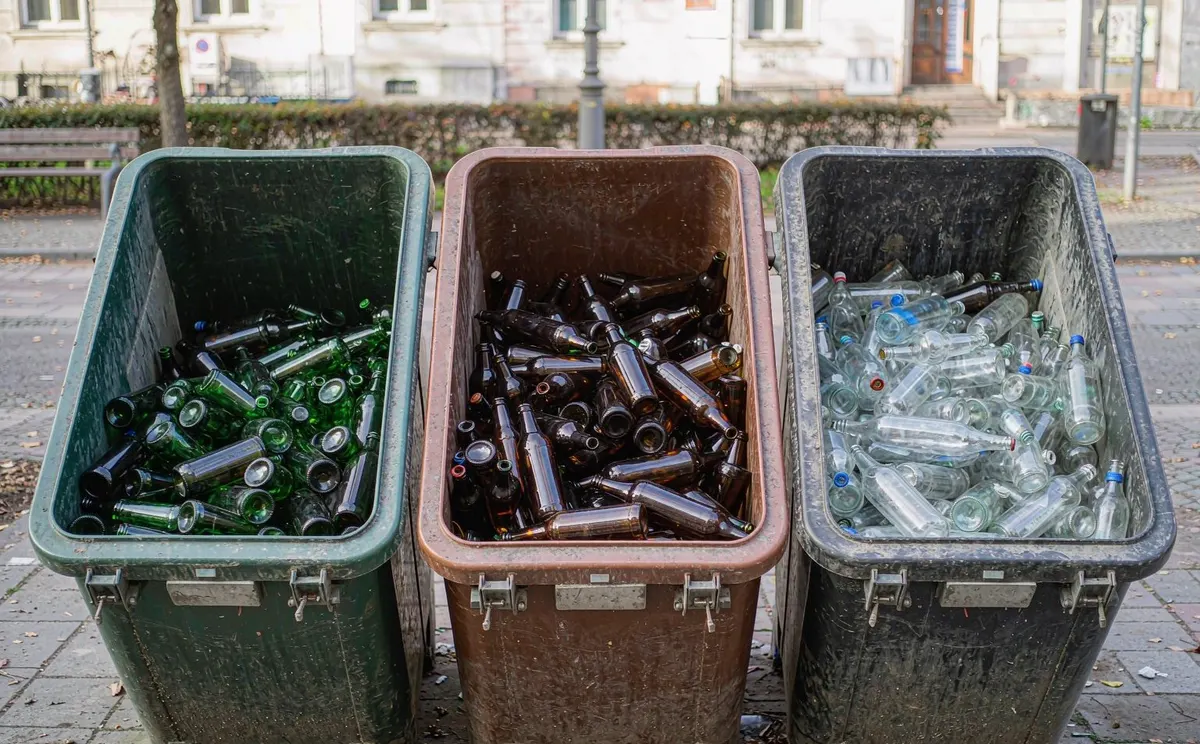 Color-sorted glass recycling containers on a European street